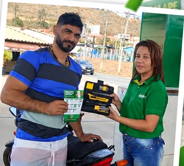 Cliente recebendo kit de ferramentas da frentista do Auto Posto Lamape